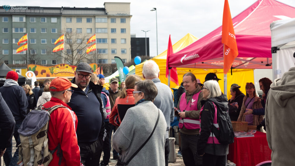 Paavo Arhinmäki ja muita vasemmistoliiton aktiiveja juttelemassa Hakaniementorilla teltan äärellä.